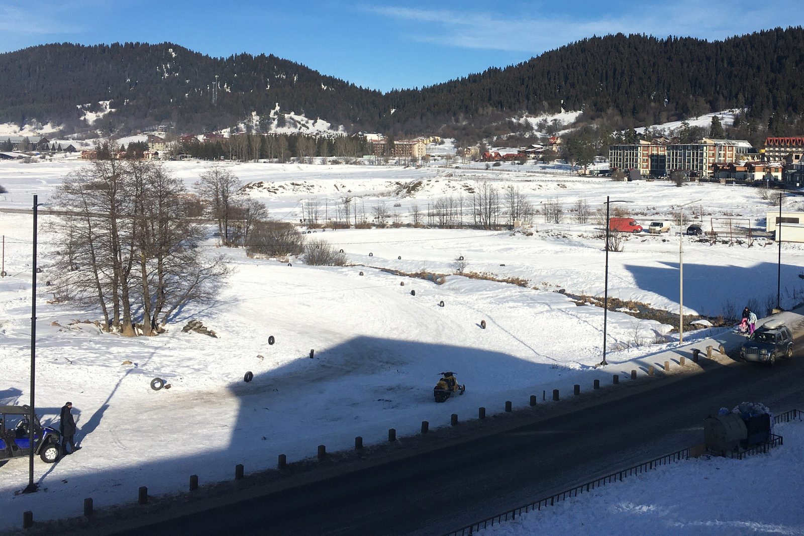 A snowy road through Bakuriani with pine-covered hills in January
