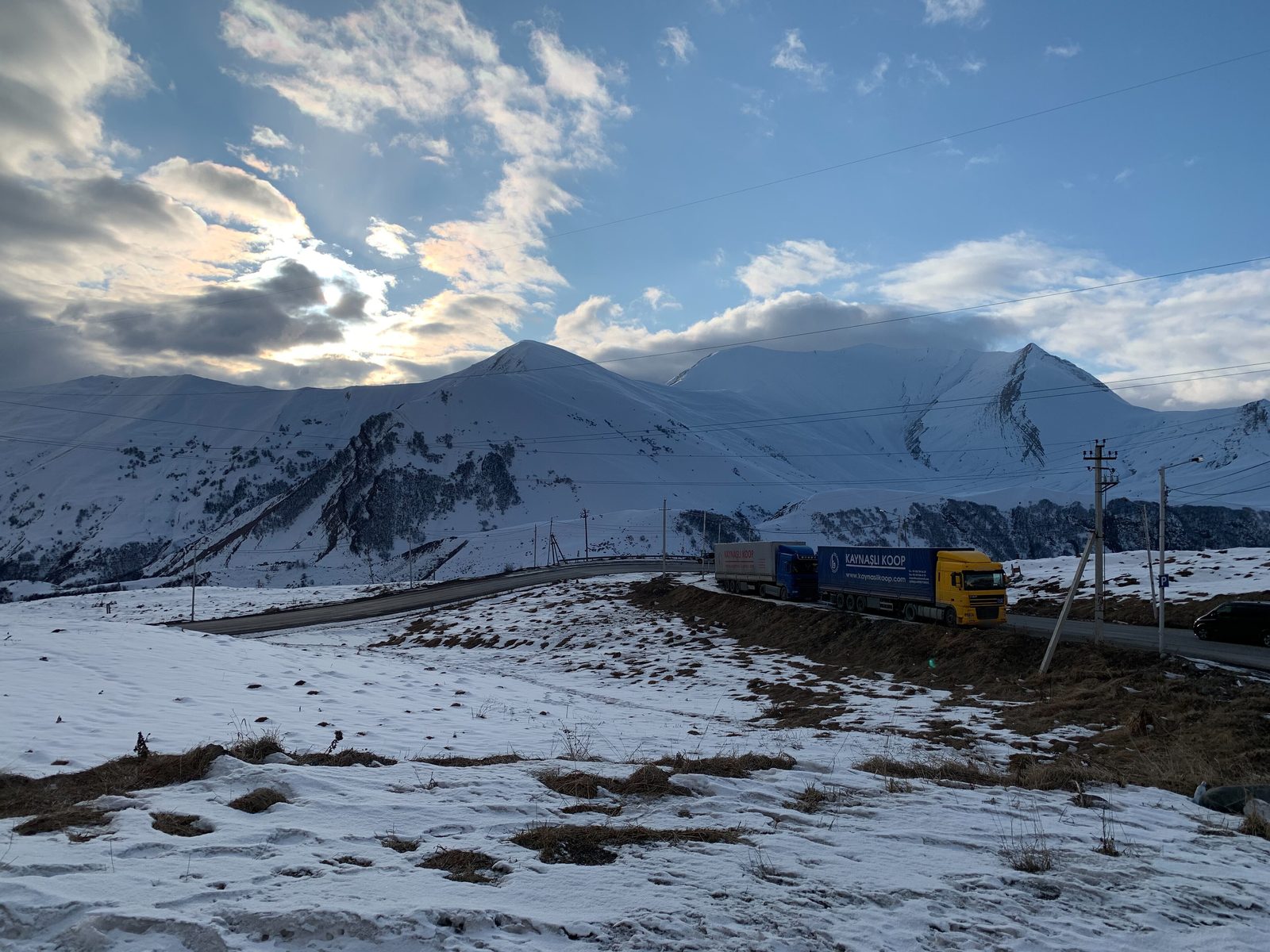 Trucks on the Georgian Military Road among snow-covered mountains in January